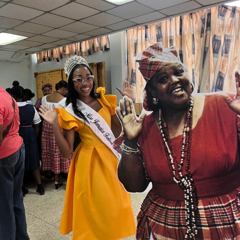 Brithney Clarke, Miss Jamaica Festival Queen 2025 and Jamaica Library Service (JLS) Reading Ambassador, shares a lighthearted moment beside a cut-out of the Honourable Louise Bennett-Coverley, OM, OJ, MBE, affectionately known as “Miss Lou,” at the Kingston and St Andrew Miss Lou Lunch Hour Concert & Exhibition on September 12