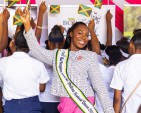 The 2026 Kingston and St. Andrew Festival Queen, Danielle Cox, celebrates with young mothers waving Jamaican flags during the launch of her community project, aimed at empowering teenage mothers through education, mentorship and personal development.
